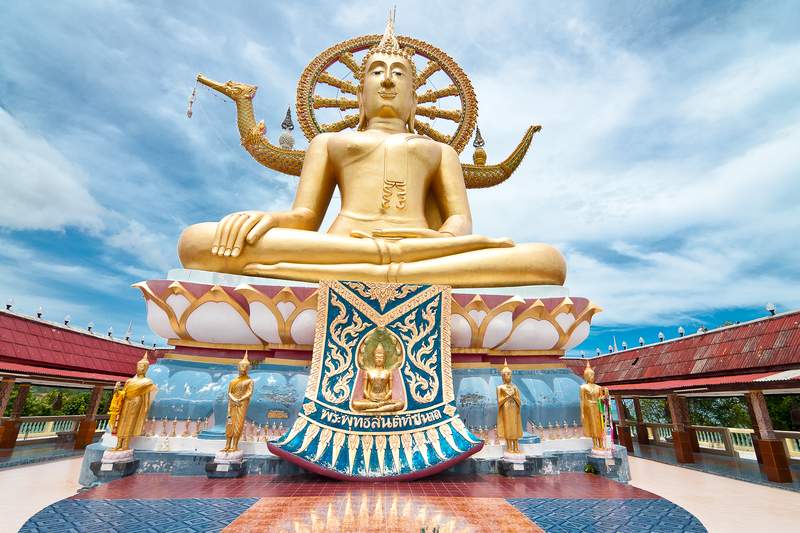 พระพุทธรูปองค์ใหญ่สีทองประทับนั่งบนฐานดอกบัว
